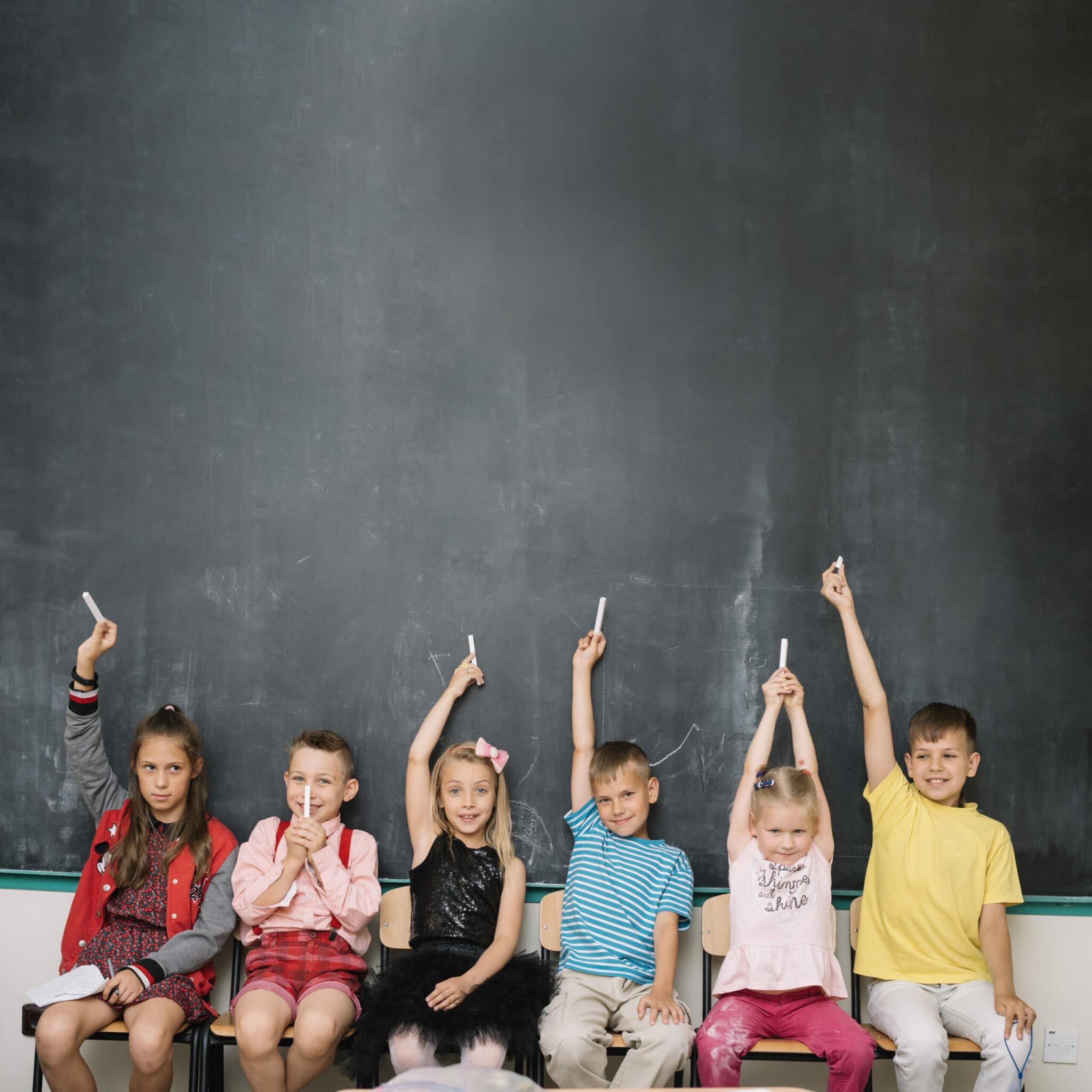 Niños en el colegio delante de la pizarra